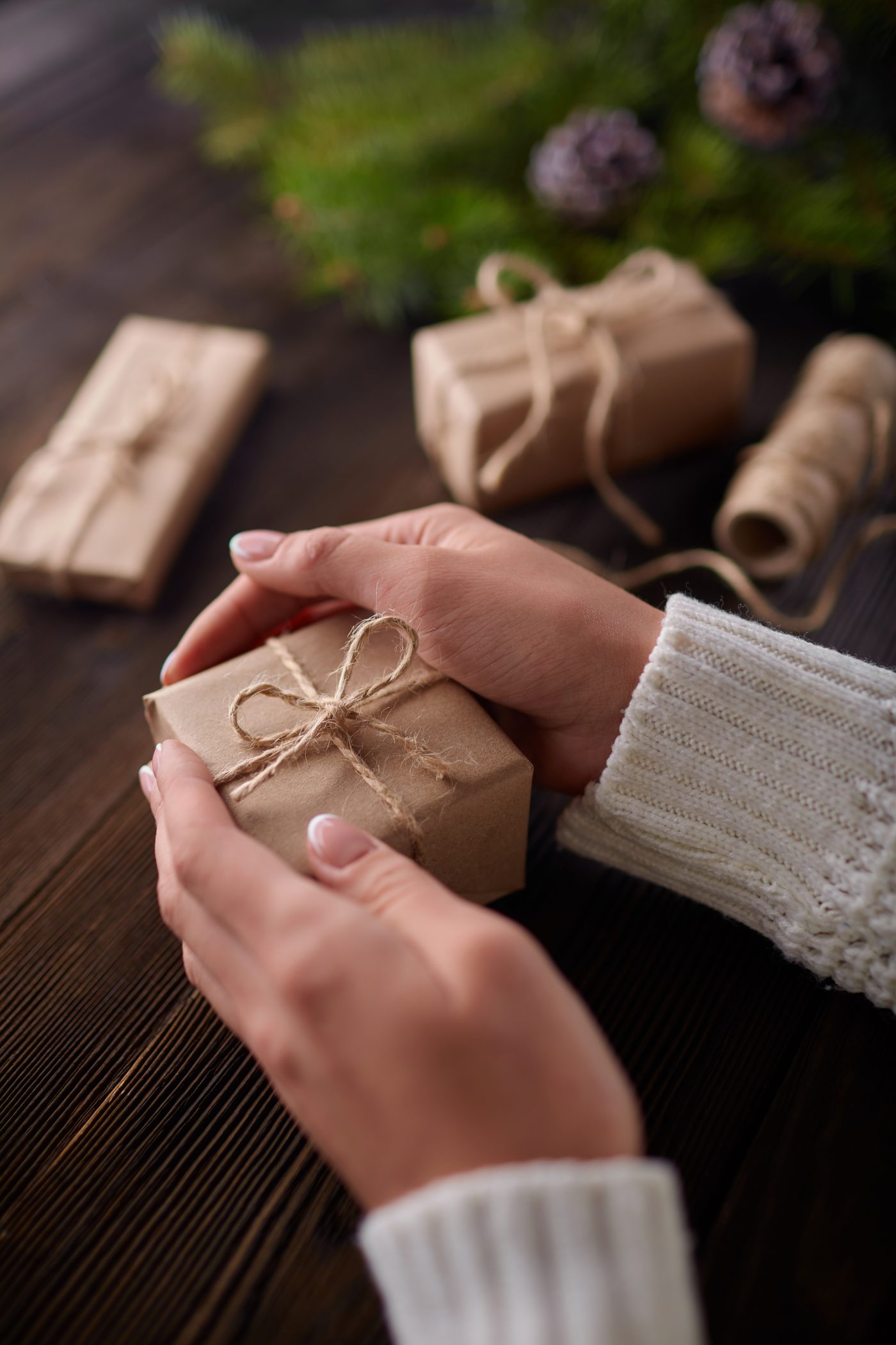 Hands holding kraft paper gifts tied with string